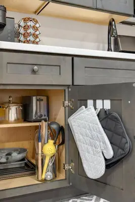 a kitchen cabinet with a sink and utensils at Barnwood Suite - Main Street Lodge in Berlin in Berlin