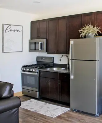 a kitchen with a stainless steel refrigerator and a stove at Maple Suite - Main Street Lodge in Berlin in Berlin