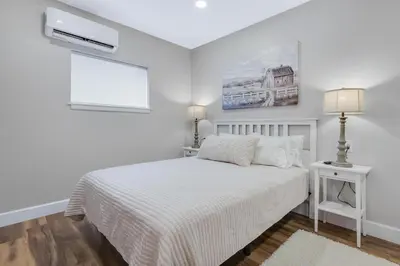 a white bedroom with a bed and a window at Sycamore Suite - Main Street Lodge in Berlin in Berlin