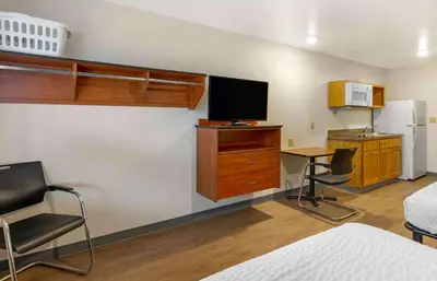 a room with a bed and a desk with a television at Extended Stay America Select Suites - Cleveland - Airport in Cleveland
