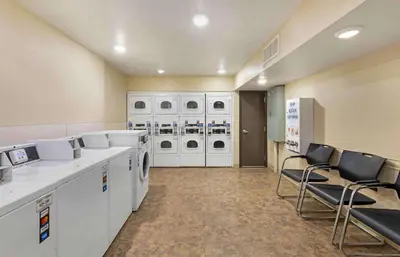 a laundry room with washing machines and chairs in it at Extended Stay America Select Suites - Cleveland - Airport in Cleveland