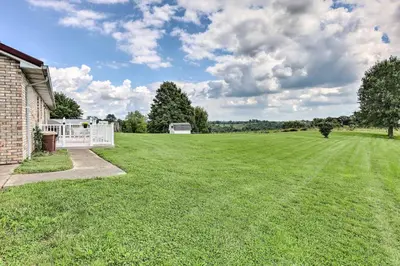 a large grassy yard with a house and a field at Charming Williamstown Retreat with Private Yard in Williamstown