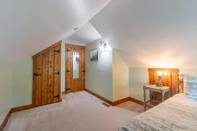 a bedroom with a bed and a wooden door at Maple Leaf Cabin in Millersburg