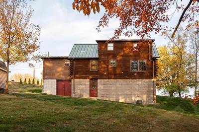 an old wooden house with a garage on a hill at Maple Leaf Cabin in Millersburg