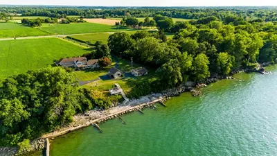 an aerial view of a house on the shore of a river at Cozy Lakefront Cottage in Huron