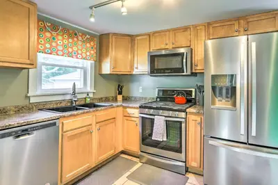 a kitchen with wooden cabinets and stainless steel appliances at Sweetwater Hideaway - Blocks to Lake Erie! in Port Clinton