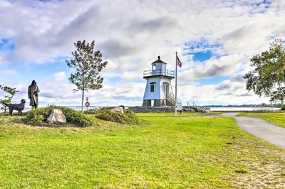 a man and a dog standing in front of a lighthouse at Sweetwater Hideaway - Blocks to Lake Erie! in Port Clinton