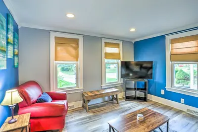a living room with a red couch and a tv at Sweetwater Hideaway - Blocks to Lake Erie! in Port Clinton