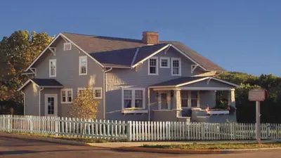 a house with a white fence in front of it at Holiday Inn Express & Suites Cambridge by IHG in Cambridge