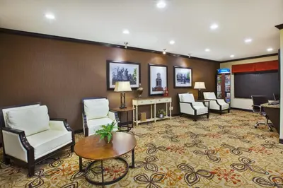 a hotel lobby with chairs and a table at Holiday Inn Express & Suites Washington - Meadow Lands by IHG in Washington