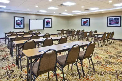 a conference room with tables and chairs and a whiteboard at Holiday Inn Express & Suites Washington - Meadow Lands by IHG in Washington