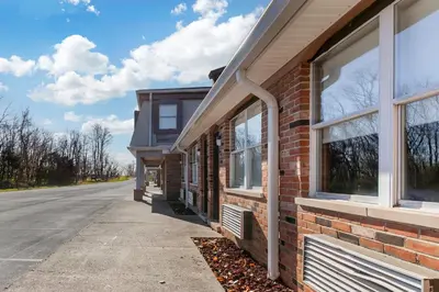 a brick building with windows on a street at HomeTowne Studios by Red Roof Georgetown, KY in Georgetown