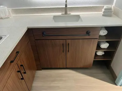 a kitchen with a sink and wooden cabinets at HomeTowne Studios by Red Roof Georgetown, KY in Georgetown
