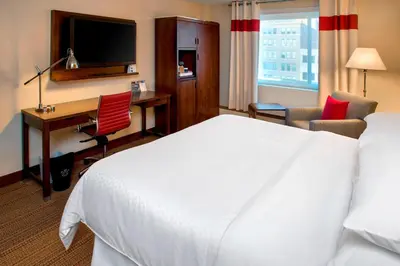 a hotel room with a bed and a desk with a computer at Four Points by Sheraton Charleston in Charleston