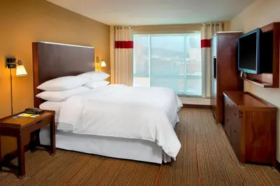 a hotel room with a bed and a television at Four Points by Sheraton Charleston in Charleston