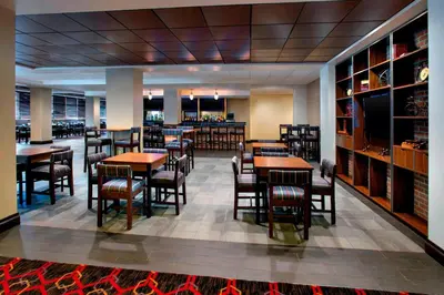 a restaurant with tables and chairs and a bar at Four Points by Sheraton Charleston in Charleston