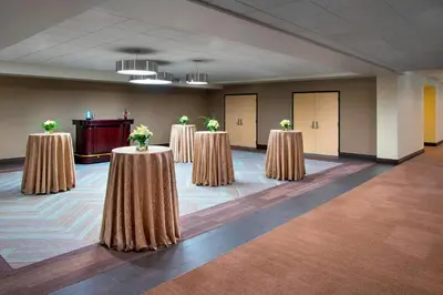 a row of tables in a room with flowers on them at Four Points by Sheraton Charleston in Charleston