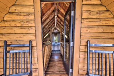 a hallway in a cabin with wooden walls and wooden stairs at Peaceful Creekside North Studio with Fire Pit in Holmesville