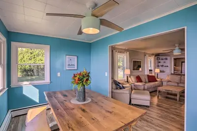 a living room with a table and a ceiling fan at Lakefront Cottage with Fishing and Private Yard! in Port Clinton