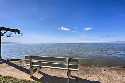 a bench sitting next to a body of water at Lakefront Cottage with Fishing and Private Yard! in Port Clinton