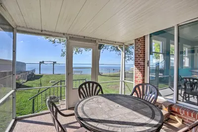 a table and chairs on a porch with a view of the ocean at Lakefront Cottage with Fishing and Private Yard! in Port Clinton