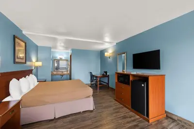 a hotel room with a bed and a flat screen tv at Americas Best Value Inn-Celina in Celina