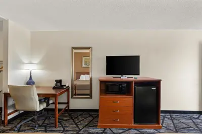 a room with a desk and a television on a dresser at Americas Best Value Inn-Celina in Celina