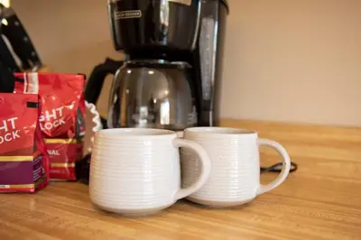 two white cups sitting on top of a counter at Biker Hiker friendly 3 bedroom by Strouds Run State Park in Athens