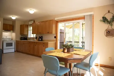 a kitchen with a wooden table and blue chairs at Biker Hiker friendly 3 bedroom by Strouds Run State Park in Athens