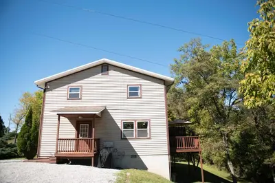 a house with a porch and a balcony at Biker Hiker friendly 3 bedroom by Strouds Run State Park in Athens
