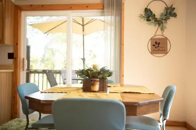 a dining room table with chairs and an umbrella at Biker Hiker friendly 3 bedroom by Strouds Run State Park in Athens