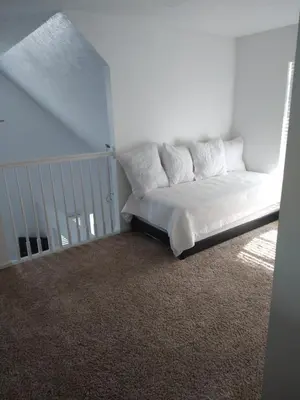 a bed with pillows in a white room at Family Friendly JUST LIKE HOME in Cleveland