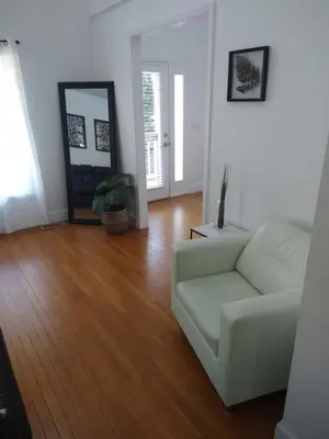 a living room with a white couch and a mirror at Family Friendly JUST LIKE HOME in Cleveland