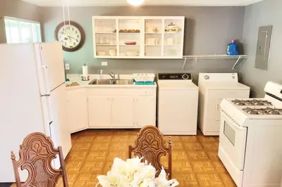 a kitchen with white appliances and white cabinets at Cheerful 3-BR home near Downtown Dayton, Wright Patterson AFB and Airport in Dayton