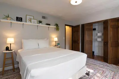 a bedroom with a large white bed and two lamps at Sleeps 12, Wooded Lot, Near Ark, Great for Family in Williamstown
