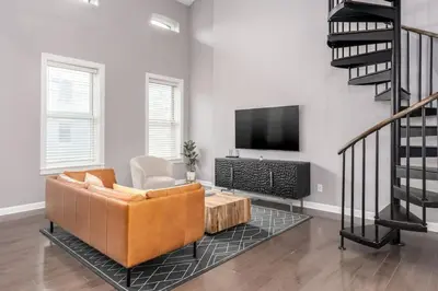 a living room with a couch and a tv at Soaring 2-Bedroom Parkside Loft Walkable to it All in Cincinnati