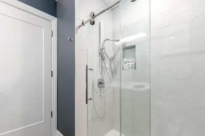 a bathroom with a shower with a glass door at Soaring 2-Bedroom Parkside Loft Walkable to it All in Cincinnati