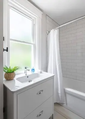 a white bathroom with a sink and a window at Deluxe 4-Bedroom w Huge Deck 3-Min to Downtown in Cincinnati