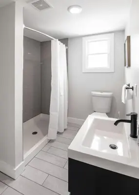 a white bathroom with a shower and a sink at Deluxe 4-Bedroom w Huge Deck 3-Min to Downtown in Cincinnati