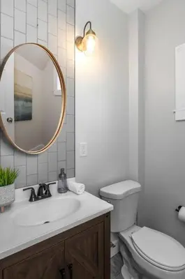 a bathroom with a sink and a toilet and a mirror at Deluxe 4-Bedroom w Huge Deck 3-Min to Downtown in Cincinnati