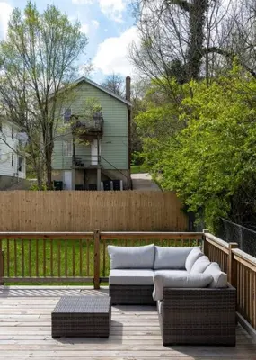a patio with a couch and chairs on a fence at Deluxe 4-Bedroom w Huge Deck 3-Min to Downtown in Cincinnati