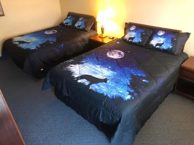 two beds in a hotel room with a bear comforter at Motel Boutique by Wolf Inn in Milan