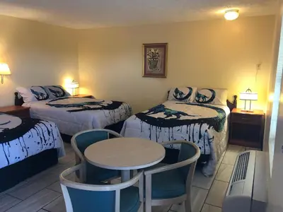 a hotel room with two beds and a table and chairs at Motel Boutique by Wolf Inn in Milan