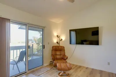 a living room with a chair and a television at Pet-Friendly Oak Harbor Condo Walk to Lake! in Sand Beach