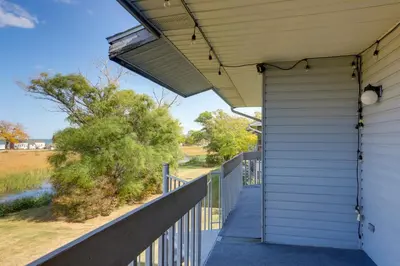 a porch of a home with a white house at Pet-Friendly Oak Harbor Condo Walk to Lake! in Sand Beach