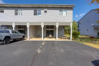 a white house with a car parked in the driveway at Pet-Friendly Oak Harbor Condo Walk to Lake! in Sand Beach