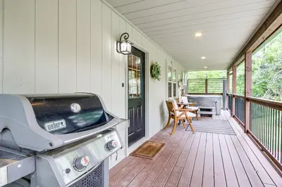 a screened in porch with a grill and a table at Idyllic Cabin in the Heart of Hocking Hills in Rockbridge