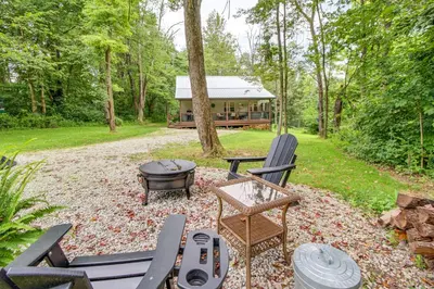 a backyard with chairs and a grill and a house at Idyllic Cabin in the Heart of Hocking Hills in Rockbridge