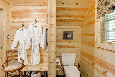 a log cabin bathroom with a toilet and a wooden wall at Idyllic Cabin in the Heart of Hocking Hills in Rockbridge