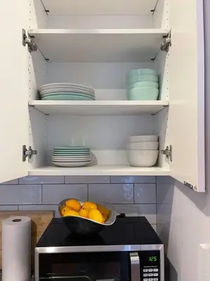 a kitchen with a bowl of oranges and plates on a microwave at CUTE & COZY/TQL stadium/ Findlay Market/Brewery in Cincinnati
